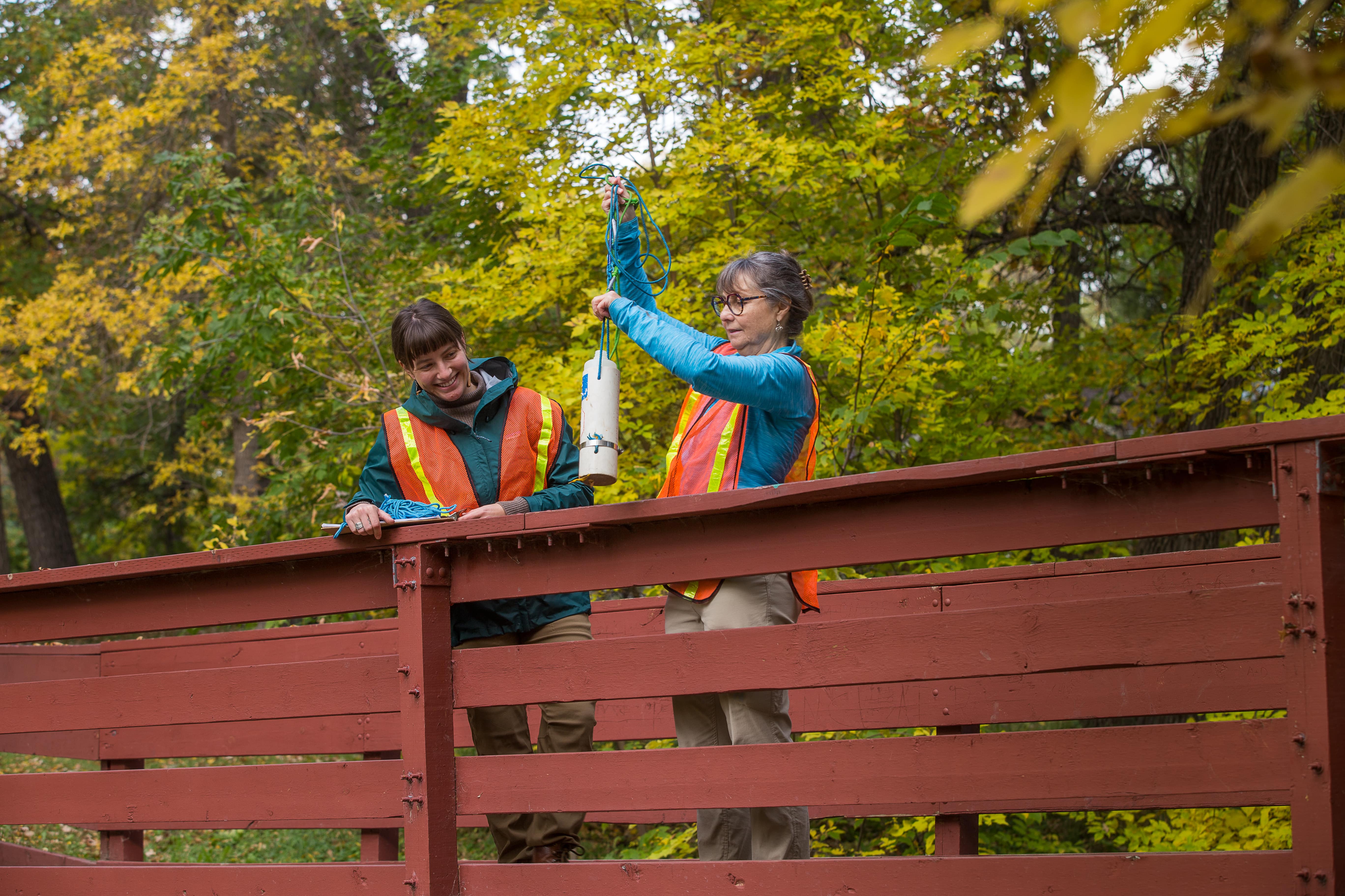 Volunteers sampling water on a bridge in the fall --- Bénévoles prélevant de l'eau sur un pont à l'automne