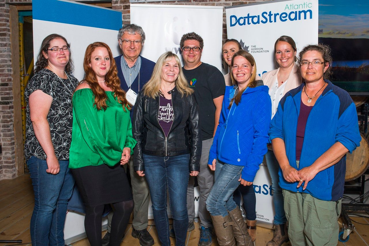 A group shot in front of datastream banner