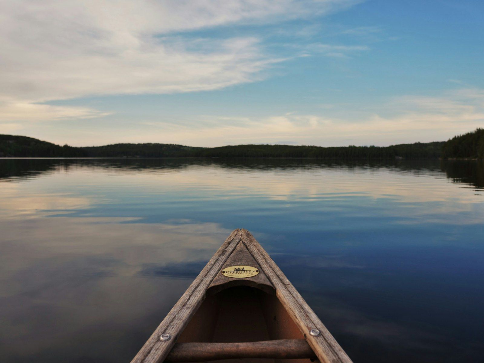 canoe centered on the water surrounded by tree line