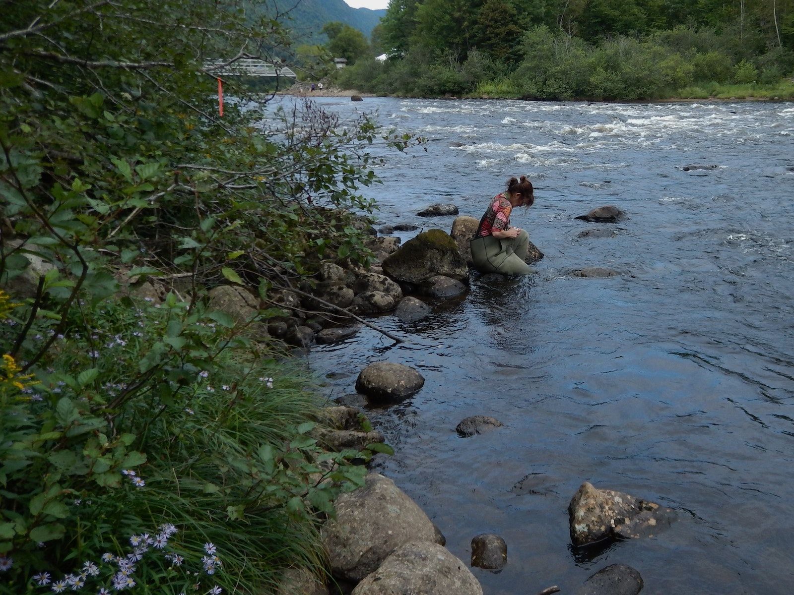 Un membre de RivTemp installant une sonde de température dans une rivière
